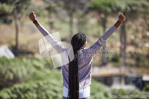 Image of Fitness success, winner woman and a forest for marathon competition, exercise training or nature hiking with yes, goal and energy. Winning hands sign of sports athlete, runner or black woman in woods