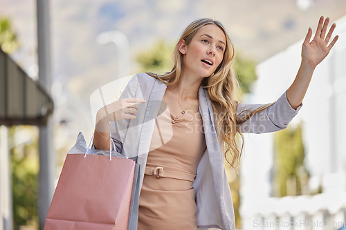 Image of Shopping, city street and hand of woman for taxi in urban travel, wealth and luxury paper bag. Young person or customer with boutique, shopping bag in road call or waiting for transportation service