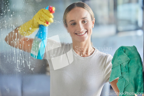 Image of Woman, spring cleaning spray and bottle for windows in house with cloth for dust, bacteria and dirt in room, apartment and home. Happy housekeeping, glass cleaner and maid with chemical detergent