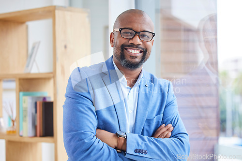 Image of Motivation, vision and mindset with a business black man CEO, manager or boss standing arms crossed in the office. Portrait, glasses and mission with a mature male employee leaning against a window