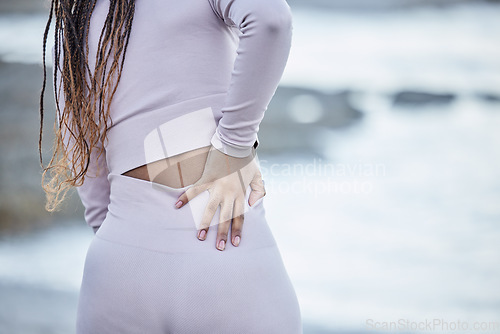 Image of Fitness, back pain and sport injury, woman runner and exercise accident outdoor, muscle ache or inflammation while running. Run, training mockup and body with pain after workout, burnout and beach.