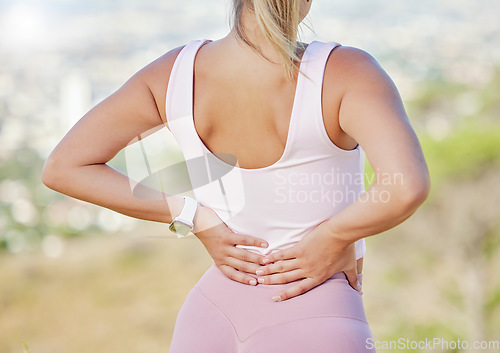 Image of Back pain, hands and woman exercise outdoor, wellness or muscle tension. Healthy female, athlete and tense rear strain in nature, fitness and workout to relax, injury or training for running or tired