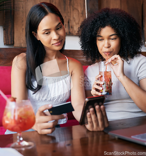 Image of Woman, friends and phone with credit card drinking at restaurant, bar or cafe making online payment or transaction. Women chilling together having a drink in ecommerce or remote banking on smartphone