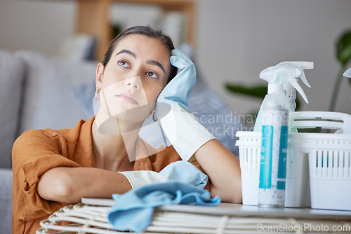 Image of Cleaning woman, thinking and bored while doing housekeeping, sanitation and disinfection of dirt, bacteria and dust in a house. Face of a lazy cleaner or maid doing maintenance with dreams and goals