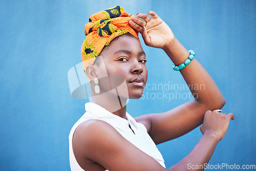 Image of Black woman, beauty and turban for face of african culture, fashion and freedom on a blue background wall for cosmetics, head scarf and makeup mockup. Portrait of female from Nigeria posing for art