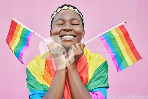 Image of Pride, lgbtq and black woman with flags in studio for queer rights. Freedom, homosexual and face of happy, lesbian or bisexual female from Nigeria with rainbow flag showing support for gay community.