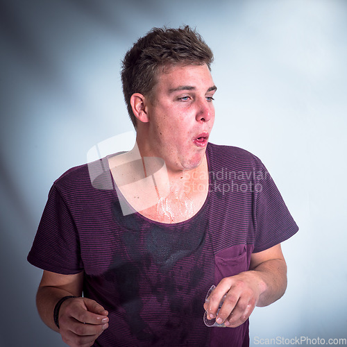 Image of Party, drunk and sick with a man in studio on a gray background about to throw up after a new year celebration. Alcohol, drink and vomit with young male feeling ill from drinking problem or addiction