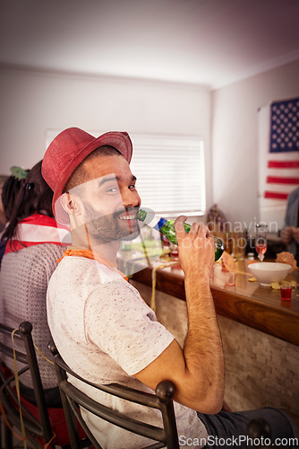 Image of Portrait, man and beer at house party, room and college dormitory in USA for new year celebration, fun and freedom. Happy guy, drinking alcohol bottle and celebrate with social friends in apartment