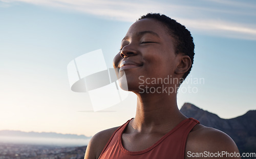 Image of Fitness, calm and breathing of black woman outdoor in nature, mountains and blue sky background for yoga wellness, meditation and zen energy. Face of girl breathing for peace, freedom and mindfulness