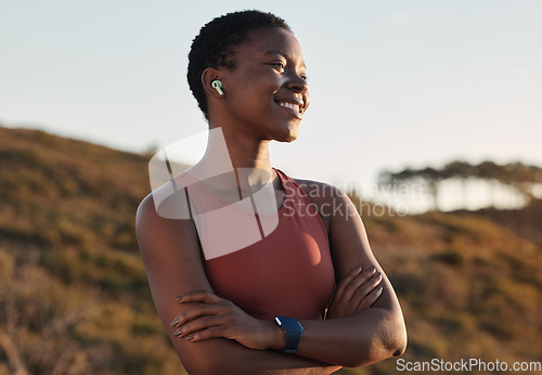 Image of Black woman runner, smile and music with earphones, nature and hill for fitness, happiness and peace. Outdoor exercise, streaming and smartwatch for girl on training, running or wellness adventure