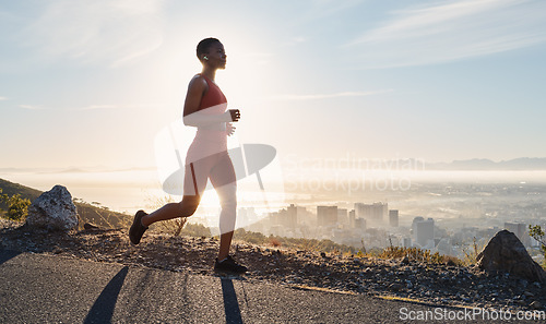 Image of Black woman, runner and fitness with music on mountain for sports wellness, podcast and cardio training outdoor. African woman, running and exercise workout or streaming radio for freedom in nature