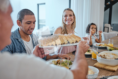 Image of Interracial family dinner, food and happiness with bonding, bread and celebration for thanksgiving. Happy family, lunch or brunch in family home for christmas, party or giving for love in Los Angeles