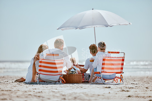 Image of Beach, umbrella and big family on a summer vacation, trip or seaside journey together in Australia. Travel, relax and children on a holiday adventure with their grandparents and parents by the ocean.