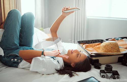 Image of Peace, phone or girl taking selfie on a bed for social media with luggage in airbnb, apartment or hotel room. Relax, freedom or happy traveler smiles taking pictures with hand gesture or sign alone