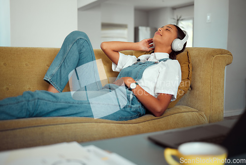 Image of Young woman, headphones and relax with music at home, peace and calm with podcast or radio, audio streaming online. Freelancer on break, work from home and wellness with sound and listening.