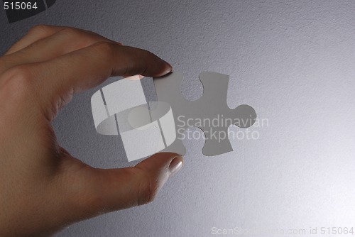 Image of Hand holding a puzzle piece