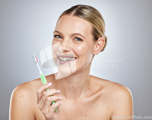 Image of Face, teeth and woman with toothbrush in studio isolated on a gray background. Oral health, dental veneers and female model getting ready to brush with toothpaste for hygiene, cleaning and wellness.