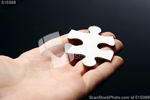 Image of Hand holding a puzzle piece