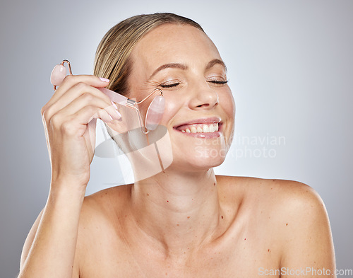 Image of Woman, crystal and face skincare beauty with smile and exfoliate in studio for health, glow and cosmetics. Model happy, skin wellness and cleaning for cosmetic detox or dermatology by studio backdrop