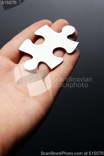 Image of Hand holding a puzzle piece
