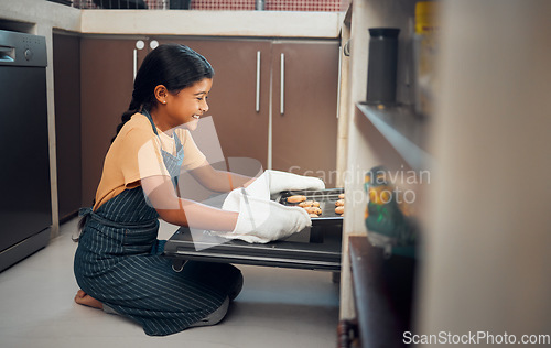 Image of Child, nutrition and cookies tray in oven kitchen for baking, child development and learning cooking skills and happy in family home. Hungry little girl, smile and bake recipe for eating in house