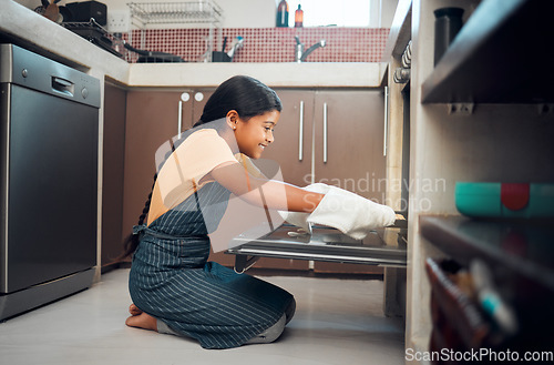 Image of Cooking, oven and girl child in kitchen holding tray after baking in home. Learning, education and happy kid teaching herself how to bake pastry, having fun and enjoying quality time alone in house.