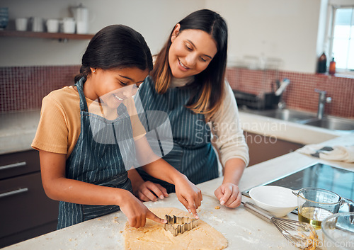 Image of Mother, girl and kitchen for teaching, cookies and learning for baking, bonding and love in family home. Woman, daughter and cooking for festive food, holiday or celebration for christmas in house