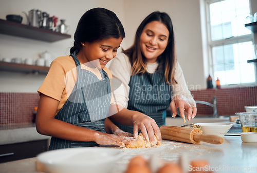 Image of Baking, family and love with a daughter and mother teaching a girl about cooking baked goods in a kitchen. Food, children and learning with an indian woman and girl together in their home to bake