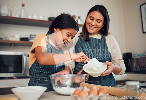 Image of Baking, family and children with a mother and daughter learning about cooking in the kitchen of their home. Food, kids and help with a girl and woman teaching her child how to bake with eggs or flour