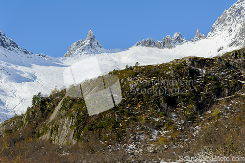 Image of high snow-capped mountains over rocks