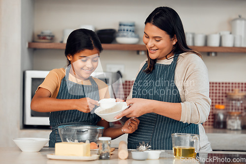 Image of Learning, family and cooking cake with mother for bonding, wellness and help with smile. Happy family, kitchen and mom teaching young daughter baking skill with flour measurement in home.