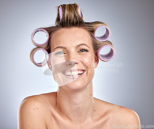 Image of Hair care, styling and woman with a roller set, beauty maintenance and happy against a grey studio background. Hair dresser, prepare and face portrait of a model curling and grooming her hair