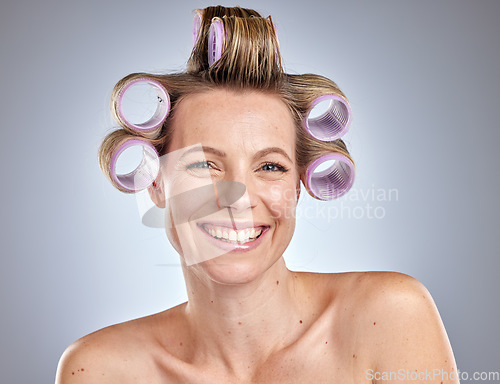 Image of Face, hair care and woman with hair roller in studio isolated on gray background. Beauty portrait, makeup and cosmetics of happy female model with salon hair treatment or curler product for hairstyle