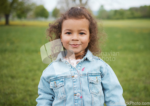 Image of Child, face and park with a smile outdoor on a grass field for freedom, play and summer vacation while happy and excited. Portrait of girl kid toddler in nature for fun spring travel adventure in UK