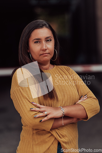 Image of A powerful portrait of a businesswoman, standing confidently with her arms crossed, representing the determination of the female gender and embodying strength and success