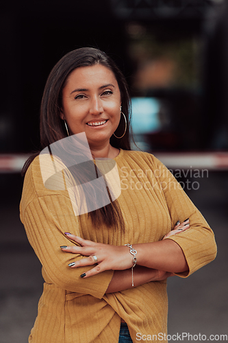 Image of A powerful portrait of a businesswoman, standing confidently with her arms crossed, representing the determination of the female gender and embodying strength and success