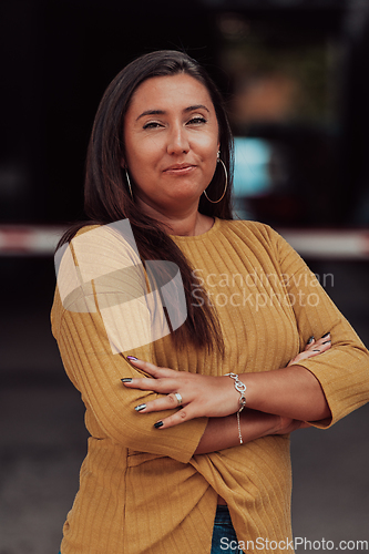 Image of A powerful portrait of a businesswoman, standing confidently with her arms crossed, representing the determination of the female gender and embodying strength and success