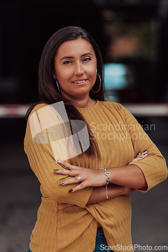 Image of A powerful portrait of a businesswoman, standing confidently with her arms crossed, representing the determination of the female gender and embodying strength and success