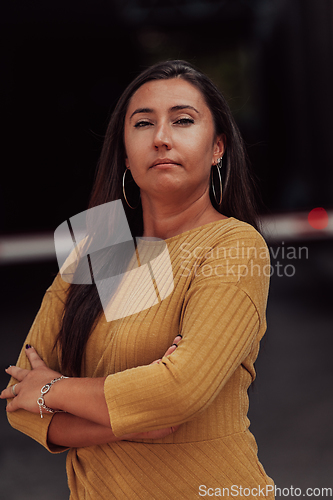 Image of A powerful portrait of a businesswoman, standing confidently with her arms crossed, representing the determination of the female gender and embodying strength and success