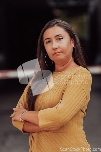 Image of A powerful portrait of a businesswoman, standing confidently with her arms crossed, representing the determination of the female gender and embodying strength and success