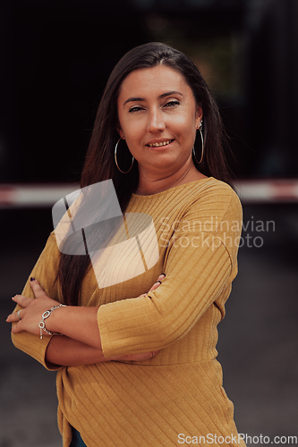 Image of A powerful portrait of a businesswoman, standing confidently with her arms crossed, representing the determination of the female gender and embodying strength and success