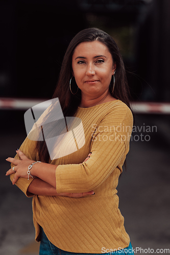 Image of A powerful portrait of a businesswoman, standing confidently with her arms crossed, representing the determination of the female gender and embodying strength and success