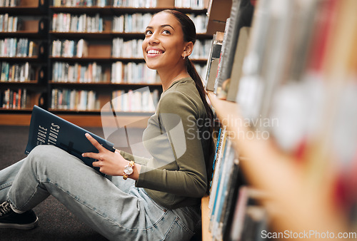 Image of Student, library and smile for reading books in learning, education or knowledge at university. Happy woman smiling enjoying book read, story or study in research for assignment or project at campus