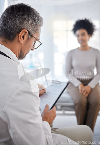 Image of Doctor, consultation and writing on clipboard with patient in hospital office for symptoms, records or notes. Healthcare, wellness or black woman consulting medical physician with checklist in clinic