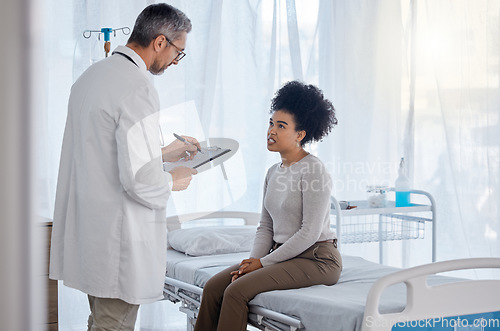 Image of Healthcare, doctor and woman consulting for insurance, documents and consent form in hospital bed. Medical, consultation and black woman with doc checklist, life insurance and permission for surgery