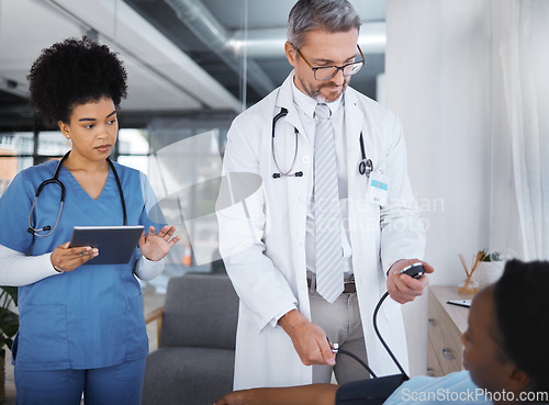 Image of Doctor, patient and blood pressure in clinic with nurse, tablet and analysis for teamwork, health or job. Healthcare expert, medical support and tech for consulting, help or wellness advice in Cuba