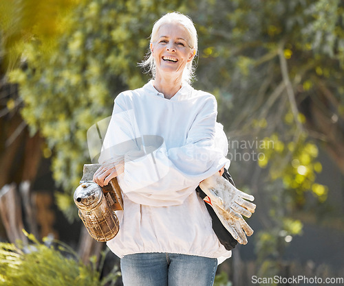 Image of Beekeeper woman, portrait and smile with protective suit, happy and work outdoor in agriculture. Senior bee farmer, happy and beekeeping ppe at farm, backyard or bee bellows for honey production