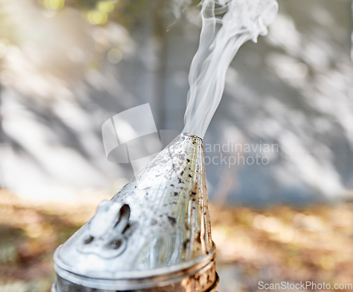 Image of Beekeeping, smoker and honey production with farm equipment outdoor in the countryside during summer. Farming, nature and agriculture with a metal container for smoke in the beekeeper industry