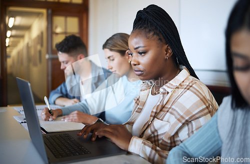 Image of University, education and group of students at desk doing project, studying and learning with laptop and notebook. Academy, college and young people taking notes in classroom, study group and lecture