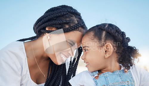 Image of Family, outdoor and love of a mother and daughter together for fun at a park while touching heads with a smile, happiness and care during travel. Black woman and child against blue sky for freedom